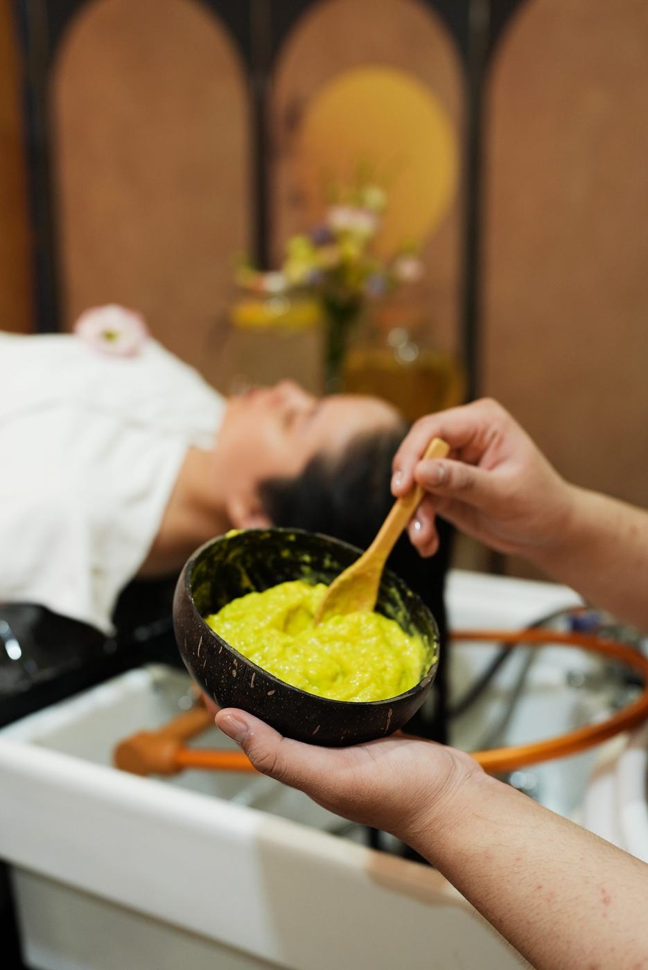 A guest receiving a herbal head spa hair wash