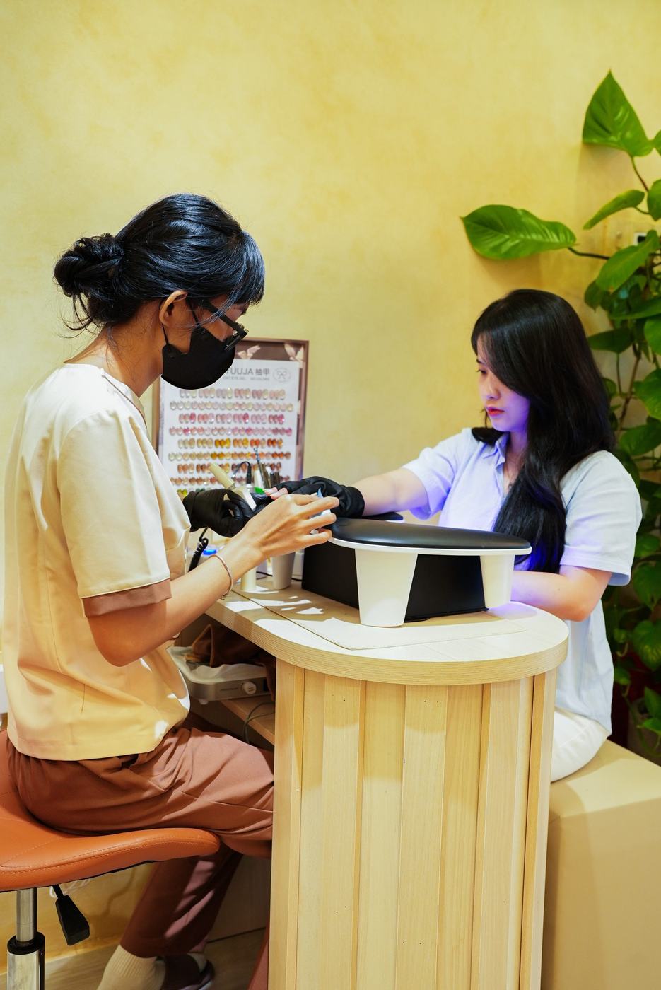 A nail technician at work on a guest's hands